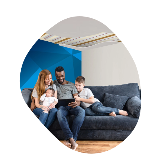 family sitting on couch with veiling heating system behind it 